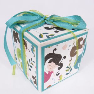 handdekorierte Schachtel mit Meerjungfrau-Motiv, Geschenkbox mit Fenster und Schleife, maritime Geschenkverpackung mit Glitzerdetails, Schachtel mit türkisfarbenem Band, Nahaufnahme Meerjungfrau auf Geschenkbox, Unterwasser-Deko auf Schachtel, Geschenkbox für Kindergeburtstag mit Meerjungfrau