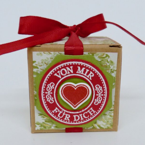 Von mir für dich Tannenbäume, handdekorierte geschenkschachtel mit stern und schriftzug, geschenkbox mit weihnachtlichem band und etikett, detailaufnahme stern auf geschenkschachtel, geschenkschachtel von oben mit schleife, seitenansicht handdekorierte weihnachtsschachtel, geschenkschachtel mit karomuster und band, weihnachtliche geschenkverpackung mit lecker-lecker motiv