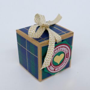 handdekorierte geschenkschachtel mit stern und schriftzug, geschenkbox mit weihnachtlichem band und etikett, detailaufnahme stern auf geschenkschachtel, geschenkschachtel von oben mit schleife, seitenansicht handdekorierte weihnachtsschachtel, geschenkschachtel mit karomuster und band, weihnachtliche geschenkverpackung mit lecker-lecker motiv