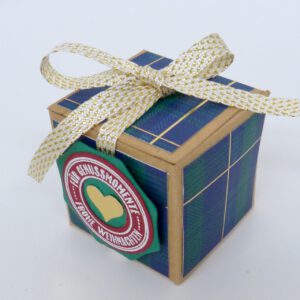 handdekorierte geschenkschachtel mit stern und schriftzug, geschenkbox mit weihnachtlichem band und etikett, detailaufnahme stern auf geschenkschachtel, geschenkschachtel von oben mit schleife, seitenansicht handdekorierte weihnachtsschachtel, geschenkschachtel mit karomuster und band, weihnachtliche geschenkverpackung mit lecker-lecker motiv