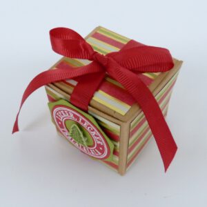 handdekorierte geschenkschachtel mit stern und schriftzug, geschenkbox mit weihnachtlichem band und etikett, detailaufnahme stern auf geschenkschachtel, geschenkschachtel von oben mit schleife, seitenansicht handdekorierte weihnachtsschachtel, geschenkschachtel mit karomuster und band, weihnachtliche geschenkverpackung mit lecker-lecker motiv