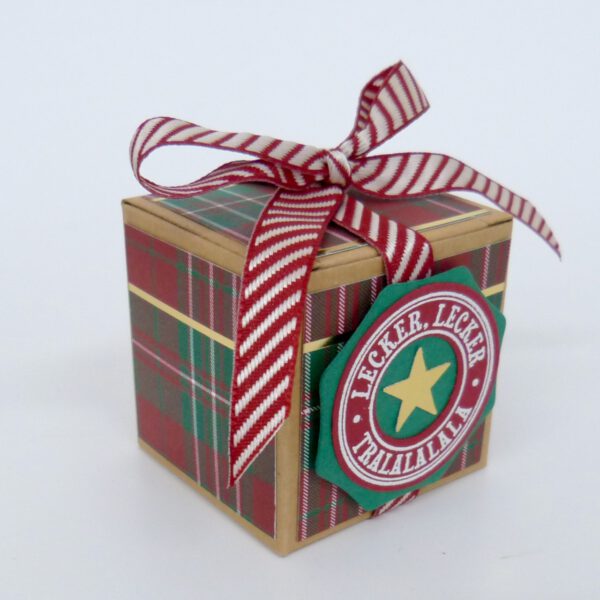 Lecker Lecker, handdekorierte geschenkschachtel mit stern und schriftzug, geschenkbox mit weihnachtlichem band und etikett, detailaufnahme stern auf geschenkschachtel, geschenkschachtel von oben mit schleife, seitenansicht handdekorierte weihnachtsschachtel, geschenkschachtel mit karomuster und band, weihnachtliche geschenkverpackung mit lecker-lecker motiv