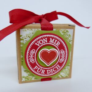Von mir für dich Tannenbäume, handdekorierte geschenkschachtel mit stern und schriftzug, geschenkbox mit weihnachtlichem band und etikett, detailaufnahme stern auf geschenkschachtel, geschenkschachtel von oben mit schleife, seitenansicht handdekorierte weihnachtsschachtel, geschenkschachtel mit karomuster und band, weihnachtliche geschenkverpackung mit lecker-lecker motiv