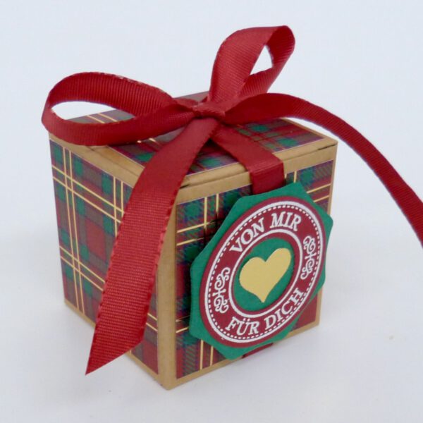 Von mir für dich, handdekorierte geschenkschachtel mit stern und schriftzug, geschenkbox mit weihnachtlichem band und etikett, detailaufnahme stern auf geschenkschachtel, geschenkschachtel von oben mit schleife, seitenansicht handdekorierte weihnachtsschachtel, geschenkschachtel mit karomuster und band, weihnachtliche geschenkverpackung mit lecker-lecker motiv