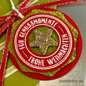 Geschenkdose Frohe Weihnachten mit Schneeflocken, Geschenkdose mit Schleifenband und Anhänger, Detailansicht Schneeflocken-Metallaccessoire, offene Geschenkdose mit Inhalt, Nahaufnahme Banderole Geschenkdose, Geschenkdose als Geschenkverpackung, handgemachte Weihnachtsdose mit Etikett