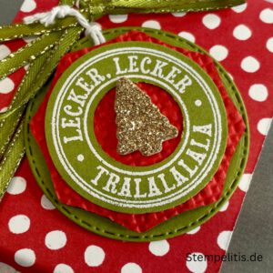 Geschenkdose Frohe Weihnachten mit Schneeflocken, Geschenkdose mit Schleifenband und Anhänger, Detailansicht Schneeflocken-Metallaccessoire, offene Geschenkdose mit Inhalt, Nahaufnahme Banderole Geschenkdose, Geschenkdose als Geschenkverpackung, handgemachte Weihnachtsdose mit Etikett