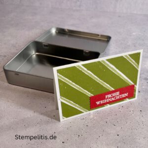 Geschenkdose Frohe Weihnachten mit Schneeflocken, Geschenkdose mit Schleifenband und Anhänger, Detailansicht Schneeflocken-Metallaccessoire, offene Geschenkdose mit Inhalt, Nahaufnahme Banderole Geschenkdose, Geschenkdose als Geschenkverpackung, handgemachte Weihnachtsdose mit Etikett