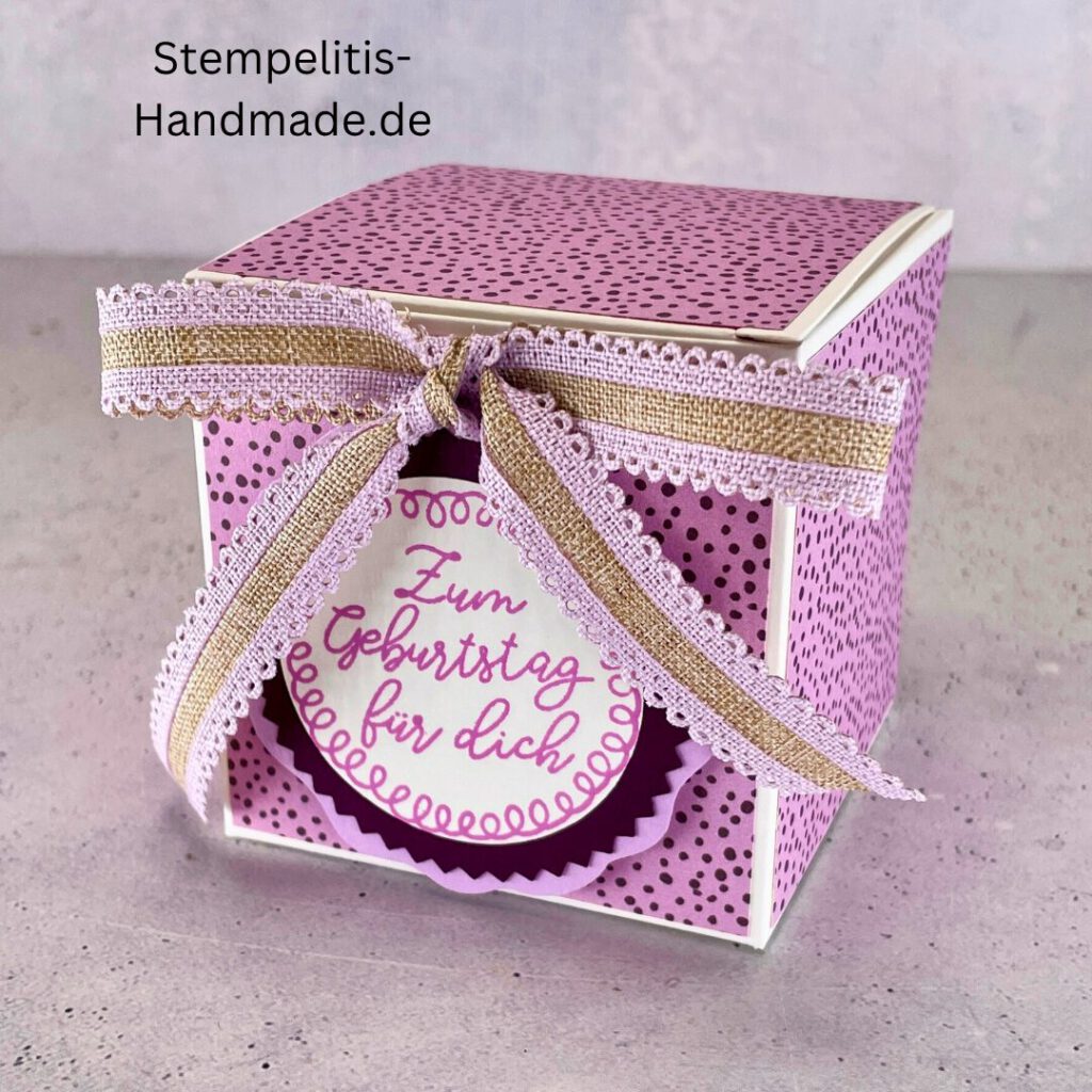 Handdekorierte Geschenkschachtel mit Schleife und Etikett „Zum Geburtstag für dich“, Offene Geschenkbox, Detailansicht Schleife und Etikett, Schachtel von oben – dekoratives Muster, Box in Nahaufnahme mit Akzentband