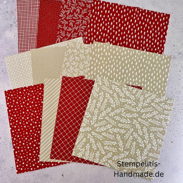 Bastelmaterialien für weihnachtliche Karten oder Projekte. Zu sehen sind grünes und rotes Tonpapier, gemustertes Designerpapier, ein Stempelset namens „Verzierte Lebkuchen“ mit passenden deutschen Sprüchen, metallische Stanzformen für Weihnachtsmotive (Stern, Glocke, Schneeflocke, Kugel), rote und weiße Kordel, goldene Zierdeckchen sowie Briefumschläge