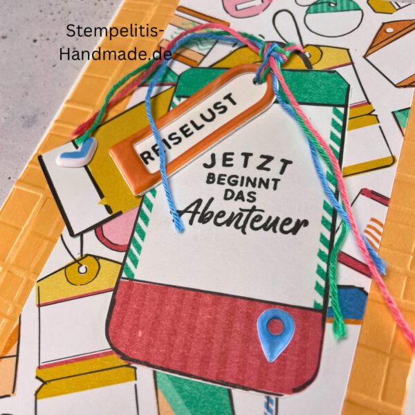 Handgemachte Karte mit Reise,Karte Reiselust mit Reise-Tags und Schleife, Karte Reiselust auf buntem Papier mit Weltmotiv, Layout der handgemachten Karte Reiselust mit Tags, Ansicht handgemachte Reiselust-Karte für Abenteuer, Geschenkidee Reisegruß handgemachte Karte Reiselust