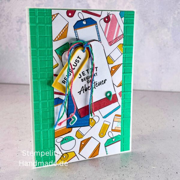 Handgemachte Karte mit Reise,Karte Reiselust mit Reise-Tags und Schleife, Karte Reiselust auf buntem Papier mit Weltmotiv, Layout der handgemachten Karte Reiselust mit Tags, Ansicht handgemachte Reiselust-Karte für Abenteuer, Geschenkidee Reisegruß handgemachte Karte Reiselust