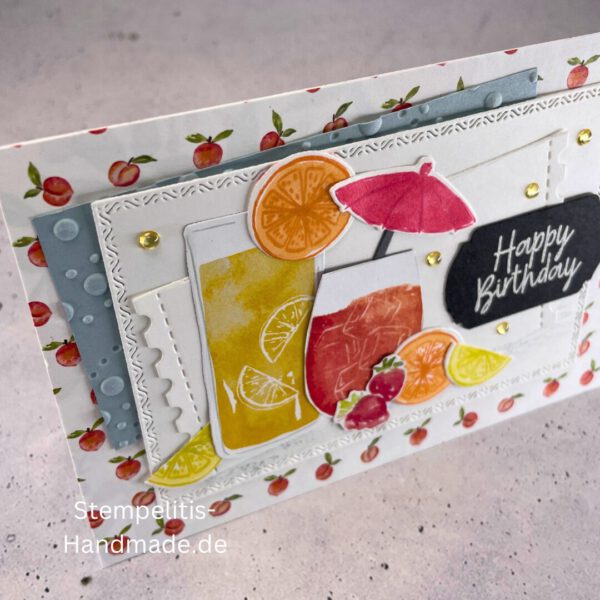 Geburtstagskarte handgemacht mit Cocktailmotiv und Obstdeko, Detailansicht Erdbeeren und Zitronenscheibe auf Geburtstagskarte, close-up Prägung und Perlendeko der Geburtstagskarte, sommerliche Geburtstagskarte handgemacht mit Pfirsich-Hintergrund, Ansicht der Karte inklusive Umschlag, fröhliche Geburtstagspost mit handgemalter Deko, Geburtstagskarte mit „Happy Birthday“-Schriftzug und Obstmotiven