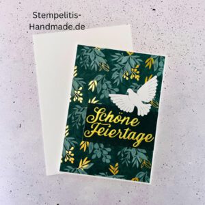 Handgemachte Weihnachtskarte mit Taube, Detailfoto Deko auf Weihnachtskarte, Nahaufnahme edler Schriftzug Frohe Weihnachten, Übersicht handgemachte Weihnachtskarte mit Umschlag, Detail handgemachte Schneeflocke mit Glitzer, Arrangement Weihnachtskarte mit grüner Hintergrundfarbe, Close-up auf Weihnachtskarte