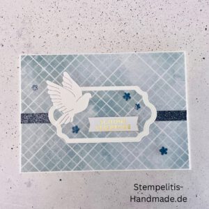 Handgemachte Weihnachtskarte mit Taube, Detailfoto Deko auf Weihnachtskarte, Nahaufnahme edler Schriftzug Frohe Weihnachten, Übersicht handgemachte Weihnachtskarte mit Umschlag, Detail handgemachte Schneeflocke mit Glitzer, Arrangement Weihnachtskarte mit grüner Hintergrundfarbe, Close-up auf Weihnachtskarte