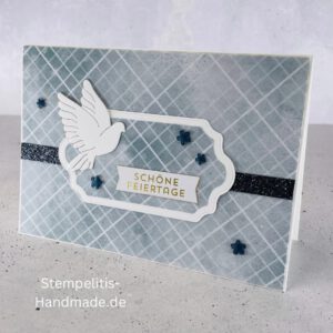 Handgemachte Weihnachtskarte mit Taube, Detailfoto Deko auf Weihnachtskarte, Nahaufnahme edler Schriftzug Frohe Weihnachten, Übersicht handgemachte Weihnachtskarte mit Umschlag, Detail handgemachte Schneeflocke mit Glitzer, Arrangement Weihnachtskarte mit grüner Hintergrundfarbe, Close-up auf Weihnachtskarte