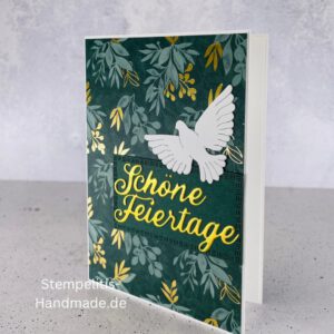 Handgemachte Weihnachtskarte mit Taube, Detailfoto Deko auf Weihnachtskarte, Nahaufnahme edler Schriftzug Frohe Weihnachten, Übersicht handgemachte Weihnachtskarte mit Umschlag, Detail handgemachte Schneeflocke mit Glitzer, Arrangement Weihnachtskarte mit grüner Hintergrundfarbe, Close-up auf Weihnachtskarte