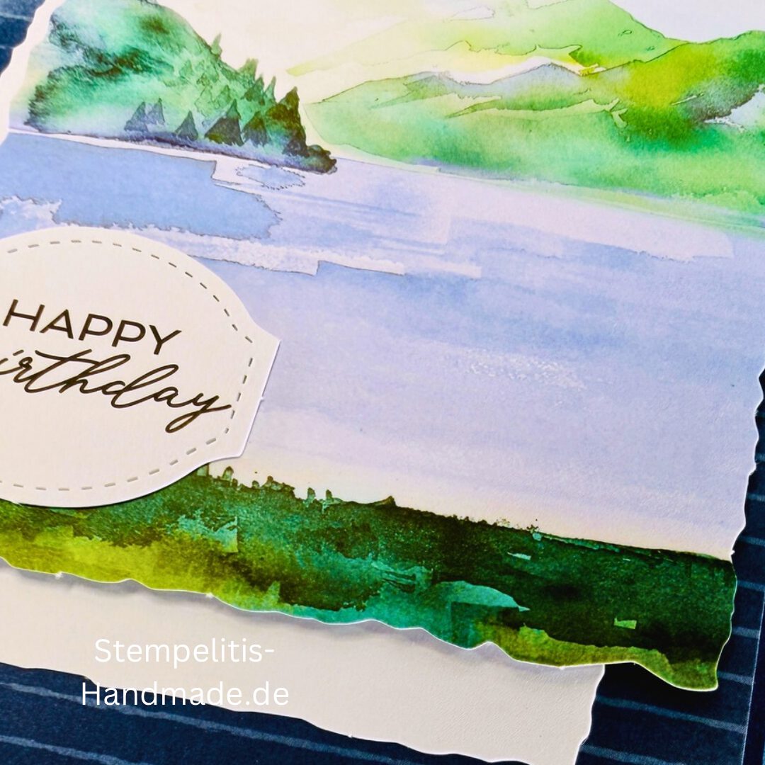 Handgemachte Geburtstagskarte mit Aquarell Landschaft, Detailansicht der Karte mit grünem See, Nahaufnahme vom handgemalten Motiv, Karte auf hellem Betonhintergrund präsentiert, Künstlerische Karte mit Berge und Wasserfarbe, Glückwunschkarte offen und geschlossen, Rückseite der Geburtstagskarte mit Platz für eigenen Text