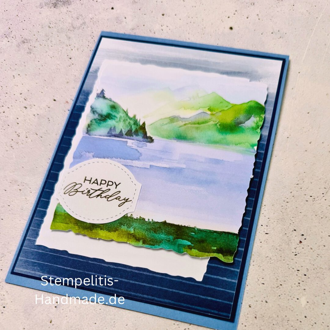 Handgemachte Geburtstagskarte mit Aquarell Landschaft, Detailansicht der Karte mit grünem See, Nahaufnahme vom handgemalten Motiv, Karte auf hellem Betonhintergrund präsentiert, Künstlerische Karte mit Berge und Wasserfarbe, Glückwunschkarte offen und geschlossen, Rückseite der Geburtstagskarte mit Platz für eigenen Text