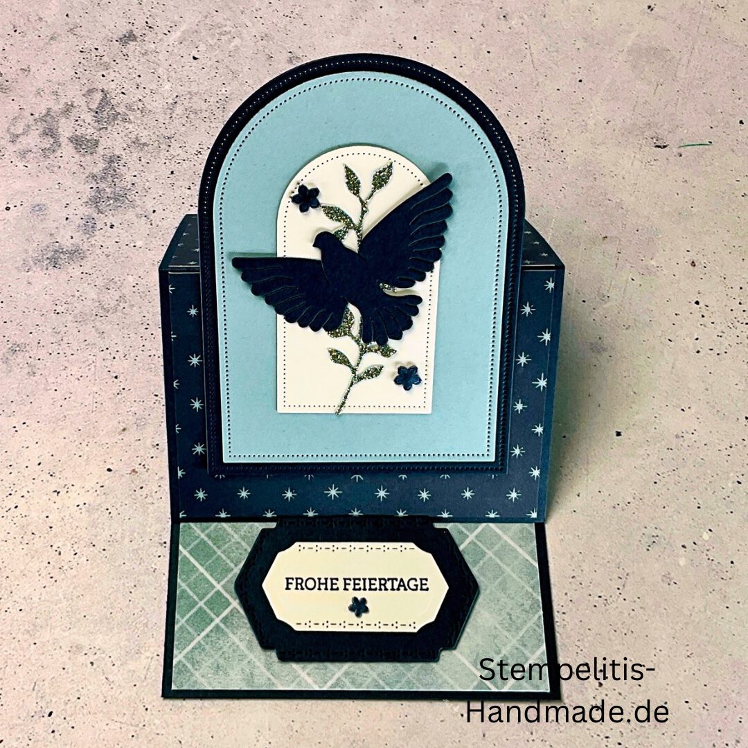 Aufstellkarte Frohe Feiertage handgemacht, Weihnachtskarte mit ausgestanzter Taube, dekorative Aufstellkarte hellblau und dunkelblau, Weihnachtsgrußkarte mit floralem Motiv, Detailaufnahme handgefertigte Weihnachtskarte, festliche Karte zum Aufstellen, elegante Frohe Feiertage Grußkarte