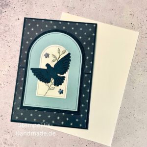 Aufstellkarte Frohe Feiertage handgemacht, Weihnachtskarte mit ausgestanzter Taube, dekorative Aufstellkarte hellblau und dunkelblau, Weihnachtsgrußkarte mit floralem Motiv, Detailaufnahme handgefertigte Weihnachtskarte, festliche Karte zum Aufstellen, elegante Frohe Feiertage Grußkarte