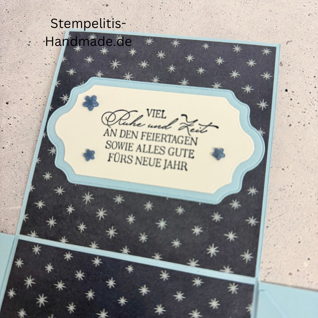 Explosionsbox in Blau mit weißer Taube, Geöffnete Explosionsbox von oben mit Geschenk und Sternenmuster, Nahaufnahme vom Deckel mit Schriftzug Festliche Grüße, Detailansicht Taube auf blauem Hintergrund, Nahaufnahme der Box innen mit Etikett, Geschenkbox im Weihnachtsdesign mit Schleife, Handgemachte Explosionsbox im festlichen Look