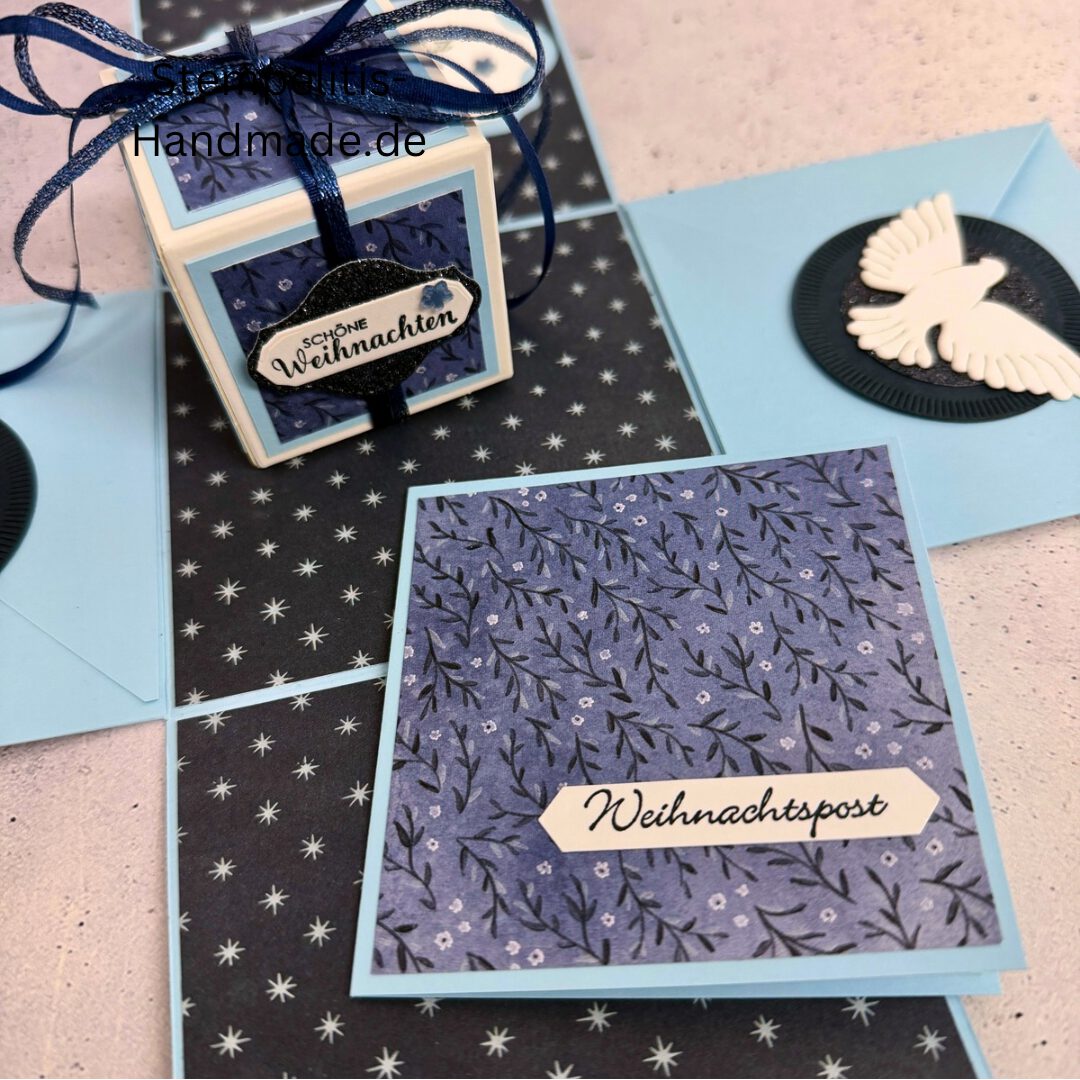 Explosionsbox in Blau mit weißer Taube, Geöffnete Explosionsbox von oben mit Geschenk und Sternenmuster, Nahaufnahme vom Deckel mit Schriftzug Festliche Grüße, Detailansicht Taube auf blauem Hintergrund, Nahaufnahme der Box innen mit Etikett, Geschenkbox im Weihnachtsdesign mit Schleife, Handgemachte Explosionsbox im festlichen Look