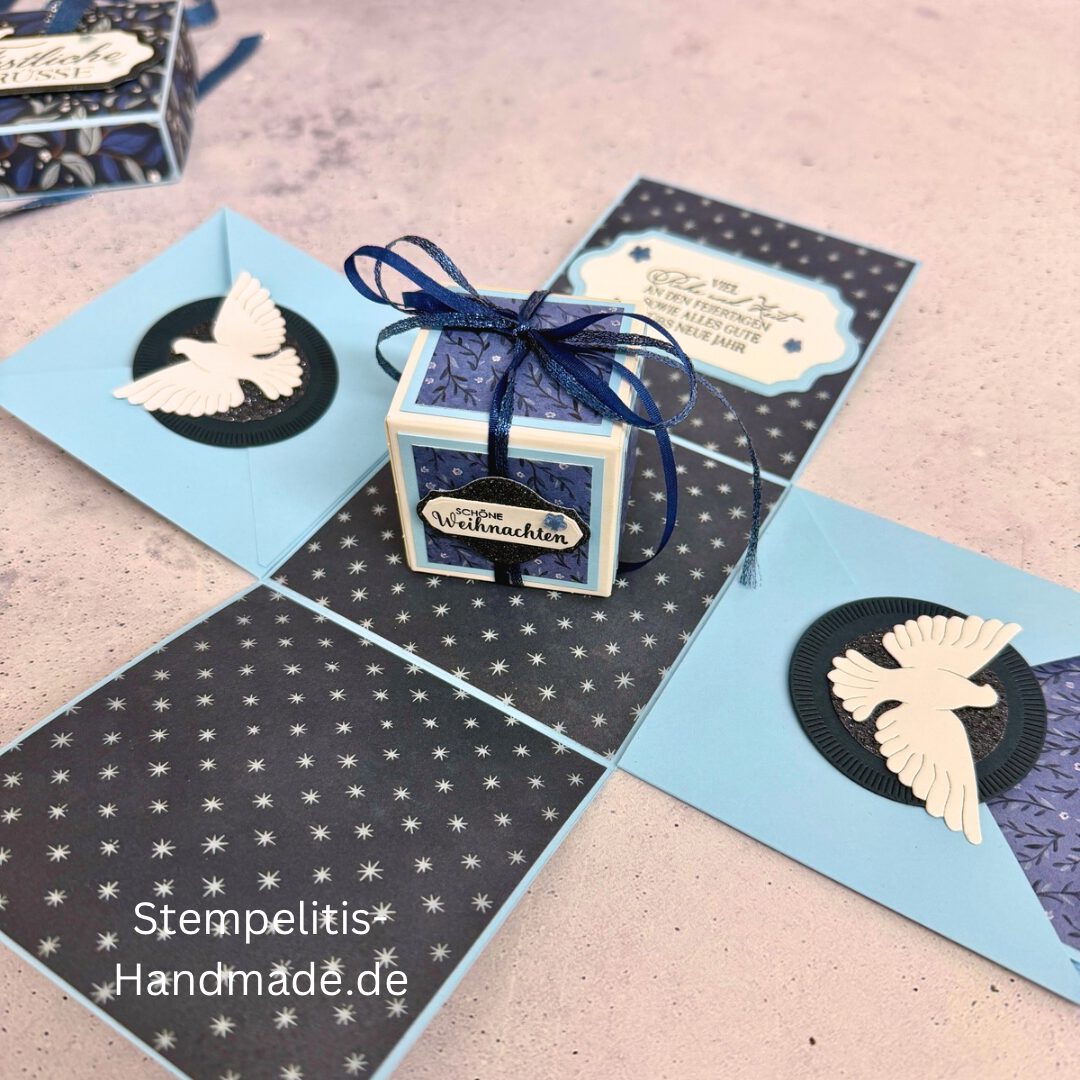 Explosionsbox in Blau mit weißer Taube, Geöffnete Explosionsbox von oben mit Geschenk und Sternenmuster, Nahaufnahme vom Deckel mit Schriftzug Festliche Grüße, Detailansicht Taube auf blauem Hintergrund, Nahaufnahme der Box innen mit Etikett, Geschenkbox im Weihnachtsdesign mit Schleife, Handgemachte Explosionsbox im festlichen Look