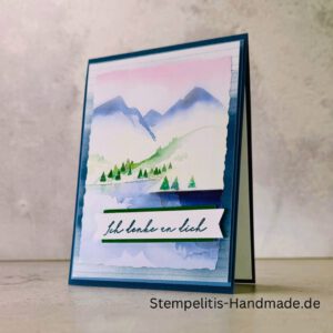 Handgemachte Karte Ich denke an dich mit Aquarell-Landschaft, Detailansicht Schriftzug Ich denke an dich auf Grußkarte, Aquarellkarte mit Bergen und Tannen als Motiv, Nahaufnahme handgemalte Grußkarte Ich denke an dich, Landschaftsaquarell auf handgemachter Karte Ich denke an dich, Geschenkidee: handgemachte Karte Ich denke an dich in Blau, Karte Ich denke an dich mit Umschlag