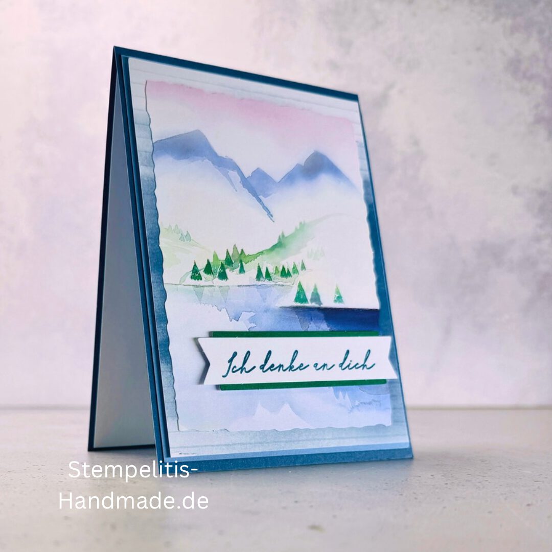 Handgemachte Karte Ich denke an dich mit Aquarell-Landschaft, Detailansicht Schriftzug Ich denke an dich auf Grußkarte, Aquarellkarte mit Bergen und Tannen als Motiv, Nahaufnahme handgemalte Grußkarte Ich denke an dich, Landschaftsaquarell auf handgemachter Karte Ich denke an dich, Geschenkidee: handgemachte Karte Ich denke an dich in Blau, Karte Ich denke an dich mit Umschlag