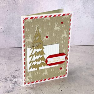 Handgemachte Weihnachtskarte mit Tannenbaum und Frohe Weihnachten Aufleger, Detailaufnahme strukturierter Hintergrund, Nahaufnahme roter Streifenrand, Kreativfoto mit Weihnachtsdeko, Tannenbaum-Design in Nahaufnahme