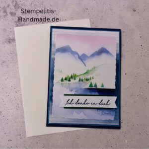 Handgemachte Karte Ich denke an dich mit Aquarell-Landschaft, Detailansicht Schriftzug Ich denke an dich auf Grußkarte, Aquarellkarte mit Bergen und Tannen als Motiv, Nahaufnahme handgemalte Grußkarte Ich denke an dich, Landschaftsaquarell auf handgemachter Karte Ich denke an dich, Geschenkidee: handgemachte Karte Ich denke an dich in Blau, Karte Ich denke an dich mit Umschlag