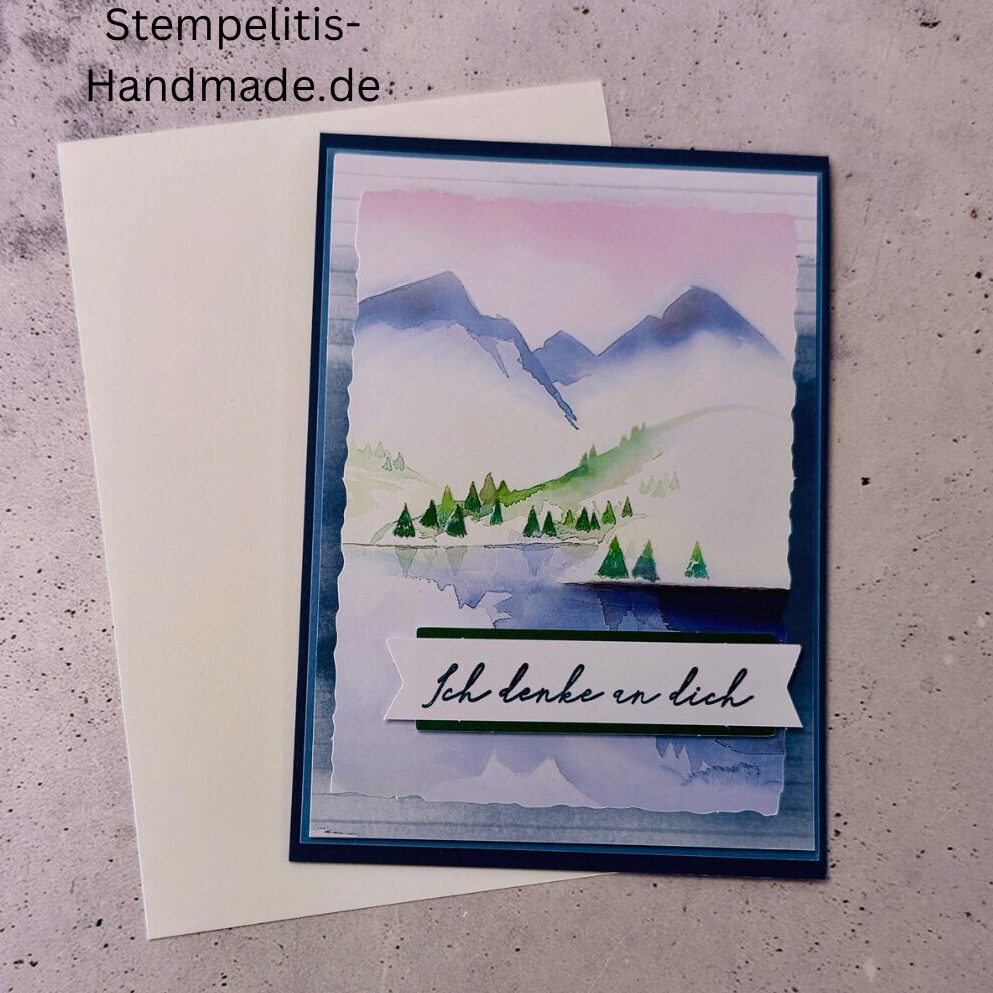Handgemachte Karte Ich denke an dich mit Aquarell-Landschaft, Detailansicht Schriftzug Ich denke an dich auf Grußkarte, Aquarellkarte mit Bergen und Tannen als Motiv, Nahaufnahme handgemalte Grußkarte Ich denke an dich, Landschaftsaquarell auf handgemachter Karte Ich denke an dich, Geschenkidee: handgemachte Karte Ich denke an dich in Blau, Karte Ich denke an dich mit Umschlag