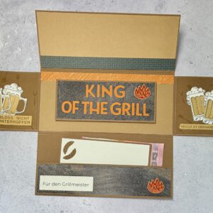 Grillmeister Aufklappkarte mit Biermotiv in maskulinem Design, handgemacht und hochwertig gestaltet Detailansicht der Grillmeister Aufklappkarte mit Bier und Grillmotiv, stilvolle handgefertigte Männerkarte Geöffnete Grillmeister Aufklappkarte mit Bier, Innenbereich mit Platz für persönliche Worte Handgemachte Grillmeister Karte mit Biermotiv auf neutralem Hintergrund fotografiert Grillmeister Aufklappkarte als Geschenkidee für Männer, hochwertig und humorvoll gestaltet Nahaufnahme der Papierstruktur und Details der handgemachten Grillmeister Aufklappkarte Grillmeister Karte mit Bier und Grillmotiv als stilvolle Aufmerksamkeit für Männer Aufklappkarte für Grillfans mit Biermotiv, elegant und mit liebevollen Details gestaltet